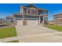 Charming two-story home with a three car garage, green lawn, and red shutters at 4211 Sandstone Dr, Mead, CO 80504