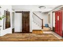 Bright entryway with wooden floors, stylish barn door, staircase and red front door at 365 Seminole Dr, Boulder, CO 80303