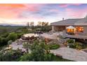 Estate home with luxury pool, patio, and manicured landscaping, ideal for outdoor entertaining, with sunset views at 606 Cliffgate Ln, Castle Rock, CO 80108
