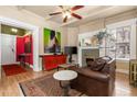 Inviting living room featuring hardwood floors, a fireplace, and a ceiling fan, complemented by colorful artwork at 1301 N Ogden St # 1A, Denver, CO 80218
