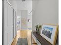 Bright hallway with hardwood floors and a console table with decorative items at 7240 W Custer Ave # 119, Lakewood, CO 80226