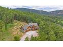 Picture-perfect exterior featuring lush landscaping, mountain views, and gorgeous architectural details at 14271 Timber Trl, Larkspur, CO 80118