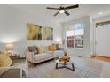 Bright living room features a ceiling fan, neutral color scheme, and a large window with natural light at 1443 S Emporia Ct, Aurora, CO 80247