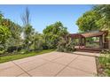 Large backyard featuring a patio, pergola covered deck, grassy area, mature trees, and landscaping for outdoor enjoyment at 8292 E Lehigh Dr, Denver, CO 80237