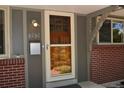 Close-up of the front door, featuring a wood door with glass accents, modern mailbox, and exterior lighting at 8292 E Lehigh Dr, Denver, CO 80237