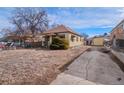 Exterior view of a cozy home featuring a side driveway and a fenced yard, perfect for suburban living at 1450 Joliet St, Aurora, CO 80010
