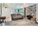 Inviting living room featuring a wood burning stove, large windows, and hardwood floors at 8075 Sunset Dr, Lakewood, CO 80214
