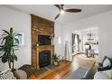 Cozy living room featuring a brick fireplace, hardwood floors, and sunlit windows at 4017 King St, Denver, CO 80211