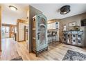 View of a hallway with light wood floors, a hutch, and a view into the kitchen on a sunny day at 148 S Holman Way, Golden, CO 80401