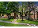 Manicured front lawn showcasing the home's charming facade with mature trees and sidewalk access at 12951 Vallejo Cir, Denver, CO 80234