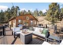 Outdoor deck featuring comfortable seating, a fire pit, and scenic views at 10180 Blue Sky Trl, Conifer, CO 80433