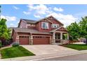 Attractive two-story home features a three-car garage, a welcoming porch, and a well-kept lawn at 10614 Kicking Horse Dr, Littleton, CO 80125