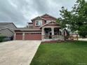 Charming two-story house with a well-maintained lawn, inviting porch, and American flag at 10614 Kicking Horse Dr, Littleton, CO 80125