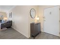Welcoming condo entryway featuring modern gray floors, cabinet with decor and a mirror, creating an inviting atmosphere at 130 N Pearl St # 304, Denver, CO 80203