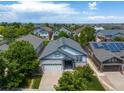 A high aerial shot showing a light blue home with solar panels on a neighboring house, and many houses surrounding it at 23421 E Long Pl, Aurora, CO 80016