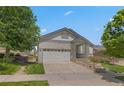 Inviting front exterior shows well kept lawn, mature trees and the home's architectural details at 23421 E Long Pl, Aurora, CO 80016
