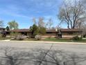 Charming single-story home featuring a brick exterior, mature trees, and a well-maintained front yard at 5600 Dover St, Arvada, CO 80002