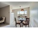 Bright dining area with a glass table, four chairs, and a view of the city skyline through the window at 1045 N Pennsylvania St # 601, Denver, CO 80203