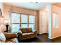 Bright living room featuring hardwood floors, a large window with blinds and two leather couches at 2346 Central Park Blvd, Denver, CO 80238