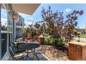Outdoor patio features iron table and chairs, gravel ground cover, a grill and beautiful trees at 2346 Central Park Blvd, Denver, CO 80238