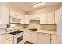Efficient kitchen with white appliances, ample cabinet space, and a bright, clean design at 3315 S Ammons St # 111, Lakewood, CO 80227