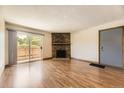 Inviting living room with wood floors, stone fireplace, and access to a private patio at 3315 S Ammons St # 111, Lakewood, CO 80227