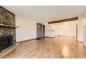 Open-concept living room featuring a fireplace and wood floors, flowing into the kitchen area at 3315 S Ammons St # 111, Lakewood, CO 80227