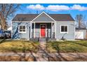 Welcoming home with a vibrant red front door and a charming, covered front porch at 4720 Perry St, Denver, CO 80212