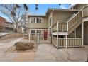 Stylish condo with a private entrance featuring a vibrant red door and secure gate at 857 S Van Gordon Ct # H101, Lakewood, CO 80228