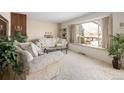 Comfortable living room with neutral carpet, large picture window, and traditional fireplace at 1288 S Drexel Way, Lakewood, CO 80232