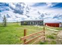 Exterior view of the home with a fenced yard and barn at 28505 County Road 5, Elizabeth, CO 80107
