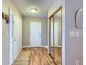 Bright foyer featuring hardwood floors, closet, and neutral paint at 14892 E Arkansas Dr, Aurora, CO 80012