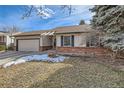 Well-maintained home showcasing a brick facade, two car garage and mature trees at 14892 E Arkansas Dr, Aurora, CO 80012