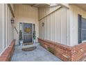 Inviting front porch with brick trim, decorative wreath, and stylish exterior lighting at 14892 E Arkansas Dr, Aurora, CO 80012