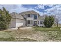 Well-maintained home boasts arched windows and inviting entrance with mature trees at 29852 E 163Rd Pl, Brighton, CO 80603