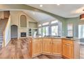 Open kitchen design features island cooktop, stone fireplace and modern finishes at 29852 E 163Rd Pl, Brighton, CO 80603
