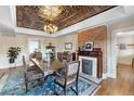 Formal dining room with decorative ceilings, ornate chandelier, and original fireplace at 7996 Bradburn Blvd, Westminster, CO 80030