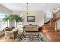 Elegant sitting room features a decorative rug, staircase, and a large, bright window at 7996 Bradburn Blvd, Westminster, CO 80030
