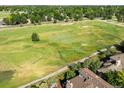 Stunning aerial view showcasing the property's proximity to a lush green golf course, with mature trees and landscape at 1175 Oakhurst Dr, Broomfield, CO 80020