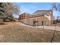Image displaying the home's backyard featuring a sunroom, garage, and patio area at 2799 S Ingalls Way, Denver, CO 80227
