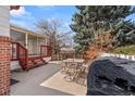 Outdoor patio with table, chairs, and grill, perfect for entertaining and enjoying the landscaped backyard at 2799 S Ingalls Way, Denver, CO 80227