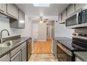 Modern kitchen with stainless steel appliances, hardwood floors in the foreground and gray cabinets at 4400 S Quebec St # 108L, Denver, CO 80237