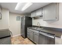 Well-organized kitchen equipped with stainless steel appliances, granite counters, and stylish gray cabinetry at 4400 S Quebec St # 108L, Denver, CO 80237