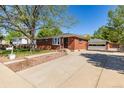 View of the charming red brick home, detached garage, and long driveway at 4953 W 61St Ave, Arvada, CO 80003