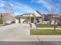 Charming home featuring a three car garage, stone accents, and a well maintained lawn at 5474 Espana St, Denver, CO 80249