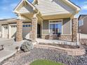 Inviting front porch with stone pillars and seating area at 5474 Espana St, Denver, CO 80249