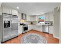 Modern kitchen boasts stainless steel appliances, white cabinetry, and a farmhouse sink at 4268 S Delaware St, Englewood, CO 80110