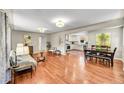 Open-concept living room and dining area featuring gleaming hardwood floors and ample natural light at 4268 S Delaware St, Englewood, CO 80110