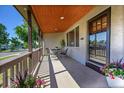 Inviting covered front porch featuring neutral brickwork and a seating area at 4268 S Delaware St, Englewood, CO 80110