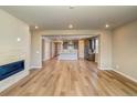 Bright, open living space with wood floors, a fireplace, and views into the kitchen at 39210 Anthony St, Elizabeth, CO 80107